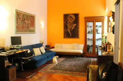 a living room with a blue couch and orange walls at B&B&Courtesy in Rome