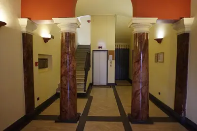 a hallway with columns in a building with stairs at Hotel Mariano in Rome