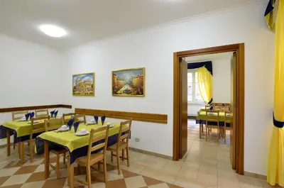 a dining room with tables and chairs and a mirror at Hotel Tex in Rome