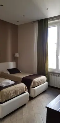 a bedroom with two beds and a window at Mia Suites in Rome