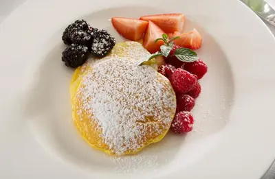 a plate of food with pancakes and fruit on it at J.K. Place Roma - The Leading Hotels of the World in Rome