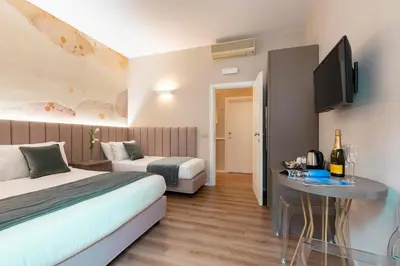 a hotel room with two beds and a table with a television at Hotel Magic in Rome