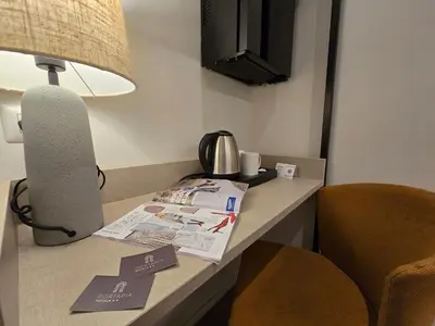 a desk in a hotel room with a lamp and papers at Hotel Porta Pia in Rome