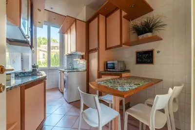 a kitchen with a counter with chairs and a table at HospitalityRome Domus Colosseo in Rome