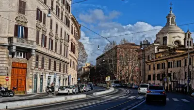 a city street with cars parked on the street at HospitalityRome Domus Colosseo in Rome