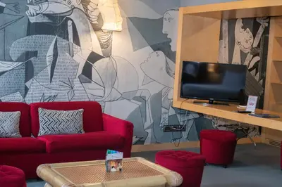 a living room with red couches and a tv at Hotel Abitart in Rome