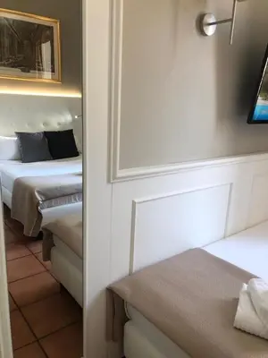 a room with two beds and a mirror at 207 Inn in Rome