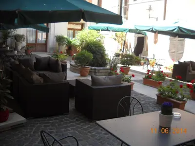 a patio with couches and tables and potted plants at Relais Hotel Antico Palazzo Rospigliosi in Rome