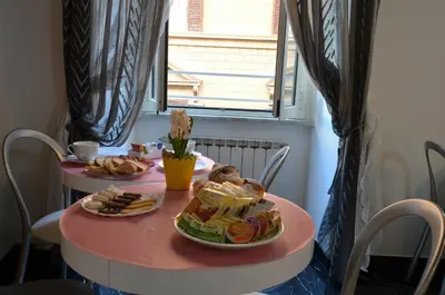 a pink table with two plates of food on it at Notti A Roma in Rome