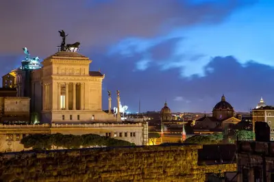 a building with a statue on the top of it at The Inn at the Roman Forum Luxury Collection - The Inn At The Roman Forum in Rome