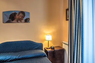 a bedroom with a bed and a picture on the wall at Hotel Caracciolo in Rome