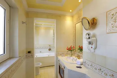 a bathroom with a tub and a sink and a bath tubermott at Hotel Homs in Rome