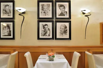 a dining room with a table and three pictures on the wall at Hotel Homs in Rome