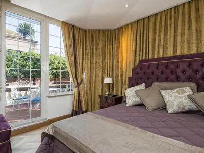 a bedroom with a purple bed and a window at The Britannia Hotel in Rome