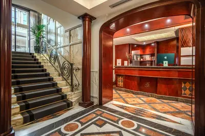 a lobby with a staircase and a bar at The Britannia Hotel in Rome