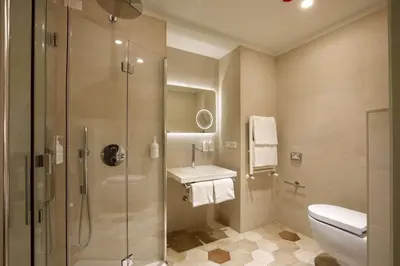 a bathroom with a shower and a toilet and a sink at Cosmopolita Rome Colosseum, Tapestry Collection by Hilton in Rome