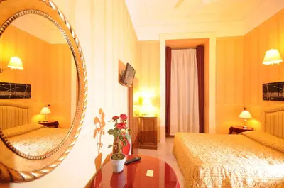 a hotel room with two beds and a mirror at Hotel Sweet Home in Rome