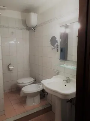 a white bathroom with a toilet and a sink at Hotel Sweet Home in Rome