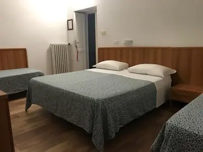 a bedroom with two beds and a wooden floor at Hotel Lodi in Rome