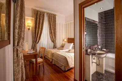 a hotel room with a bed and a bathroom at Albergo Ottocento in Rome