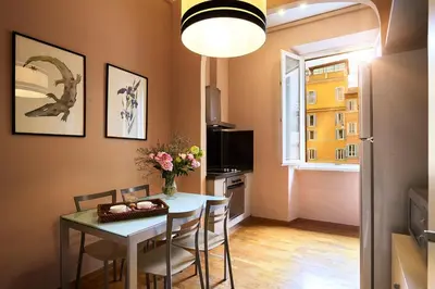 a dining room with a table and chairs and a window at Trianon Borgo Pio Aparthotel in Rome