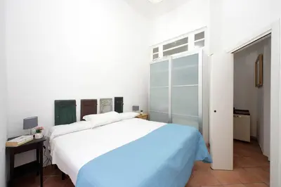 a white bedroom with a large bed and a desk at 4BNB - Quiriti Delightful Apartment in Rome