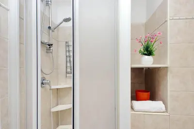 a bathroom with a shower with a toilet and a plant at 4BNB - Quiriti Delightful Apartment in Rome