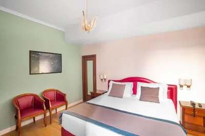 a bedroom with a large bed and two chairs at Hotel Piazza Di Spagna in Rome