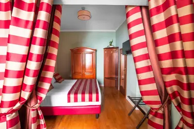 a bedroom with red and white curtains and a bed at Hotel Piazza Di Spagna in Rome