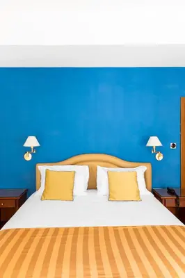 a blue bedroom with a bed with yellow pillows at Hotel Piazza Di Spagna in Rome