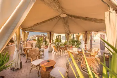 a patio with tables and chairs on a balcony at Hotel Impero in Rome