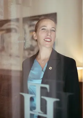 a woman in a suit standing behind a window at Hotel Traiano in Rome
