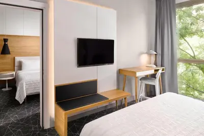 a hotel room with two beds and a table and chair at Le Meridien Visconti Rome in Rome