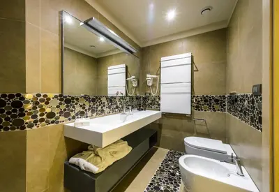 a bathroom with two sinks and a toilet at Augustana House and Suites in Rome