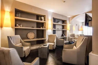 a waiting room with chairs and a clock on the wall at Hotel Villafranca in Rome