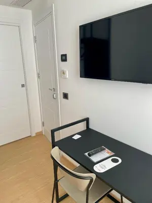 a black table and chair with a television on a wall at Hotel Patria in Rome