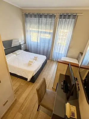 a bedroom with a bed and a desk with a computer at Hotel Laura in Rome