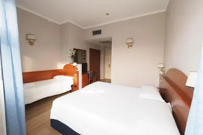 a hotel room with two beds and a mirror at Hotel Laura in Rome