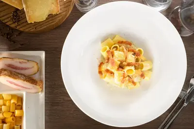 a plate of food with pasta on a table at Hotel Indigo Rome - St. George by IHG in Rome
