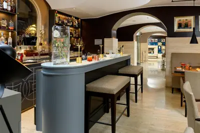 a bar in a restaurant with stools at a counter at Hotel Indigo Rome - St. George by IHG in Rome