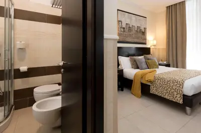 a bedroom with a bed and a bathroom with a toilet at Yes Hotel Boutique Rome in Rome