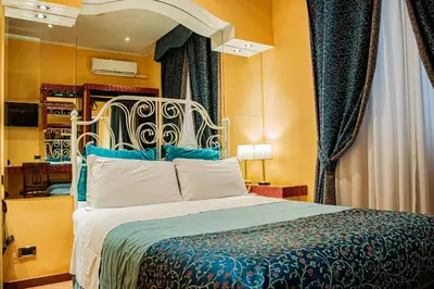 a bedroom with a large bed with blue and white sheets at Hotel Canova in Rome