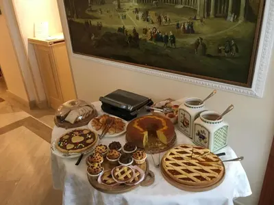 a table with various pastries and pies and a painting at Residenza RomaCentro in Rome