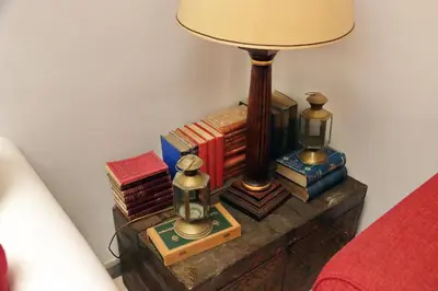 a table with a lamp and a pile of books at Sangallo Charme in Rome