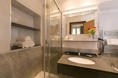 a bathroom with a sink and a shower with a mirror at Duca d'Alba Hotel - Chateaux & Hotels Collection in Rome