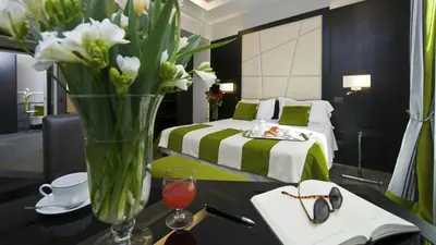 a vase of flowers on a table in a bedroom at Duca d'Alba Hotel - Chateaux & Hotels Collection in Rome