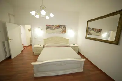 a bedroom with a white bed and a mirror at Suite Argentina in Rome