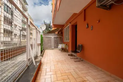 a balcony of a house with orange walls and a chair at La Casa dei Sogni di Serena in Rome