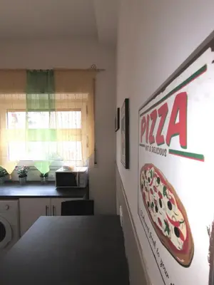 a kitchen with a pizza sign on the wall at My Vatican House in Rome