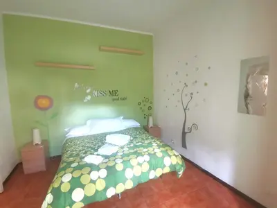 a bedroom with a bed with a green wall at My Vatican House in Rome